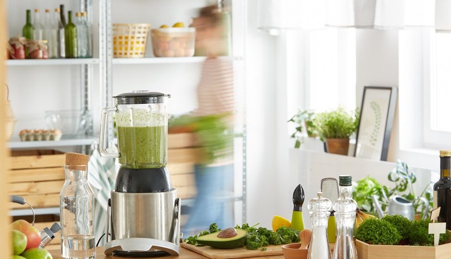 blender on the counter with greens superfood powder in the smoothie