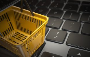 E-commerce, online shopping, internet purchases concept. Yellow shopping basket on computer laptop keyboard, 3d illustration